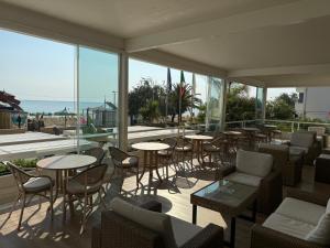 a restaurant with tables and chairs and windows at Hotel Costa Verde in Pineto