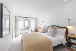 a white bedroom with a large bed with white pillows at Contemporary 2-Bed 2-Bath Home with Parking in Cheltenham