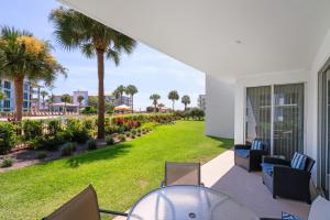 a patio with a table and chairs and a lawn at High Pointe Resort 131 in Inlet Beach