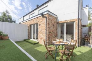 a patio with a table and chairs on a lawn at Contemporary 2-Bed 2-Bath Home with Parking in Cheltenham