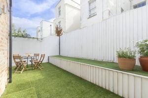 a patio with a table and chairs on a white fence at Contemporary 2-Bed 2-Bath Home with Parking in Cheltenham