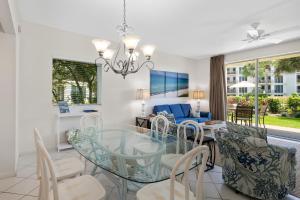 a dining room and living room with a glass table and chairs at High Pointe Resort 131 in Inlet Beach