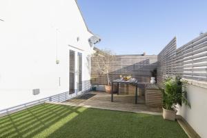 a small backyard with a table and grass at Cosy 2-Bed Apartment in Tivoli in Cheltenham