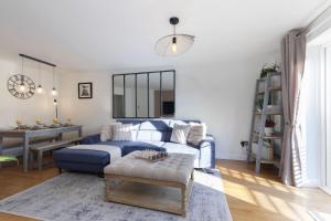 a living room with a blue couch and a table at Cosy 2-Bed Apartment in Tivoli in Cheltenham
