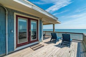 Una casa con dos sillas en una terraza con vista al océano. en New Listing Our Twilight Beach Shack - 3 BR - 2 B, en Ponte Vedra Beach