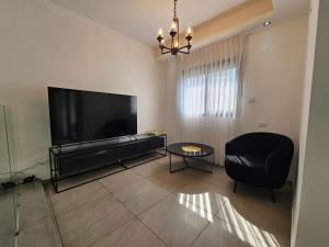 a living room with a large flat screen tv at Luxury Duplex • 3BR • Garden + Balcony • Parking in Nahariyya