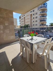 a white table and chairs on a balcony at Luxury Duplex • 3BR • Garden + Balcony • Parking in Nahariyya