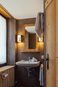 een badkamer met een wastafel en een spiegel bij Hotel Sanetsch in Gsteig +45 foto's