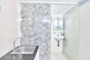 a white bathroom with a sink and a shower at H2T Hotel Center BuiVien in Ho Chi Minh City