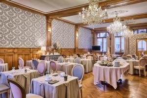 a banquet room with tables and chairs and chandeliers at The Originals Boutique, Hôtel de la Balance, Montbéliard in Montbéliard