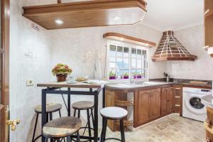 a kitchen with a sink and a counter with stools at Casa Vacacional Bevi - Tenerife Norte in Los Realejos