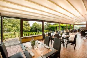 a restaurant with tables and chairs and large windows at Boma Countryhouse in Casale Bufalotta
