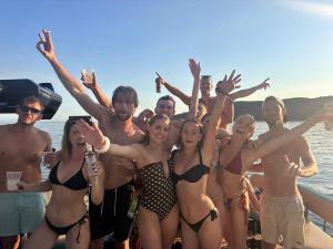 un grupo de personas en traje de baño en un barco en Oasis Hostel, en Himare