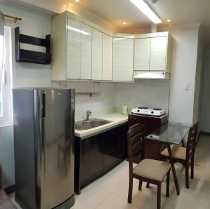 a kitchen with a stainless steel refrigerator and a table at Studio Unit in Cebu City