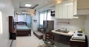 a kitchen with a sink and a bed in a room at Studio Unit in Cebu City