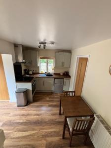 una cucina con tavolo in legno e una cucina con bancone di Self-contained 2 bedroom annexe in secluded country house a Uppingham Altre 2 foto