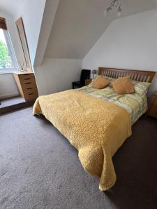 una camera da letto con un letto con una coperta gialla di Self-contained 2 bedroom annexe in secluded country house a Uppingham