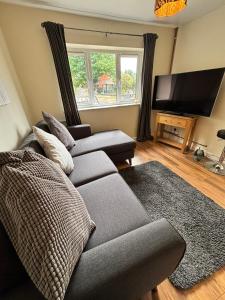 un soggiorno con divano e TV a schermo piatto di Self-contained 2 bedroom annexe in secluded country house a Uppingham