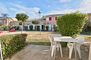 a white table and chairs in front of a building at Villa F2 piscine et jardin - Saint-Cyprien in Saint-Cyprien