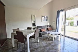 a dining room with a table and chairs and a couch at Villa F2 piscine et jardin - Saint-Cyprien in Saint-Cyprien +4 photos