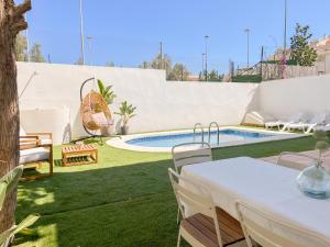 a patio with a table and chairs and a pool at Chalet Relax con Piscina privada in Águilas