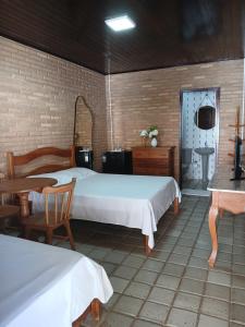 a bedroom with two beds and a table and a sink at Aluguel de suítes praia do frances in Marechal Deodoro