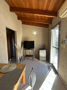 a living room with a television and a table and chairs at Complejo de Cabañas Aires de Santiago in San Antonio de Arredondo