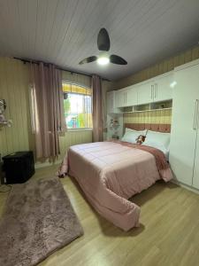 a bedroom with a bed with a dog sitting on it at Cantinho da Iraci in Foz do Iguaçu