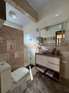 a bathroom with a sink and a toilet and a mirror at Cantinho da Iraci in Foz do Iguaçu
