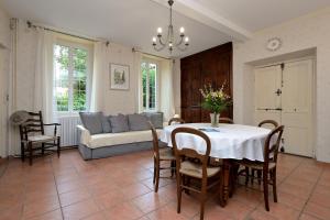 Un comedor con una mesa y un sofá. en Maison L'Arénoulat, en Aspet