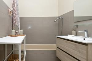 un baño con lavabo y bañera en Maison L'Arénoulat, en Aspet 13 fotos más