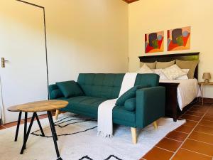 a living room with a green couch and a bed at House Cosy in Northriding
