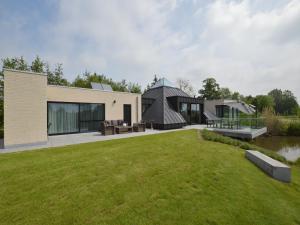 EekhoutLovely holiday home 'Walleken' with a pond的现代房屋,设有大院子