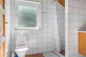 een badkamer met een toilet en een raam bij 0326-Romo-Sandloberen-3 in Mølby +32 foto's