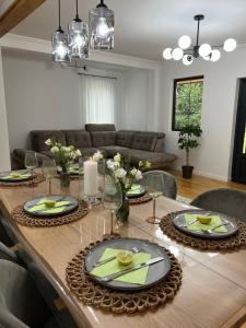 a dining room table with plates and glasses on it at Roua Chalet in Nemţişor