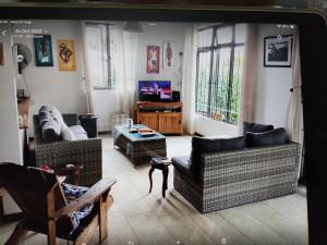 ein Wohnzimmer mit zwei Sofas und einem Fernseher in der Unterkunft Mouck's Paradise in Tambe