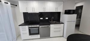 a kitchen with white cabinets and a white refrigerator at Chez Bio in Coulommiers