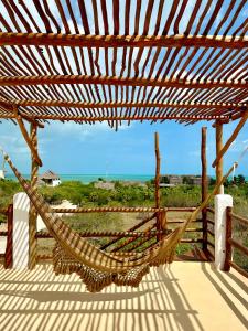 a hammock on a deck with a view of the ocean at Casa del Sol Holbox - Self Check In in Holbox Island