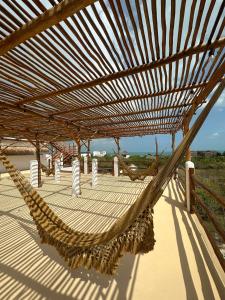 a hammock on a deck with a view of the ocean at Hotel La Casa del Sol Holbox in Holbox Island +2 photos