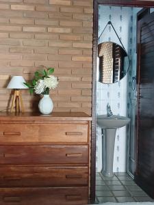 a bathroom with a dresser with a sink and a mirror at Aluguel de suítes praia do frances in Marechal Deodoro