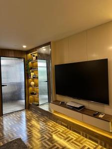 a living room with a large flat screen tv at Chobara707- Your Escape for Movies, Memories & Magic in Mohali