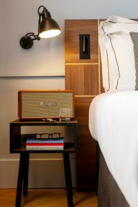a bed and a table with a box on it next to a bed at Urban Hive Milano in Milan +51 photos