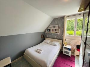 a small bedroom with a white bed and a window at Le Jardin Champenois Maison in Tinqueux