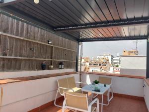 a patio with a table and chairs on a balcony at Ático acogedor, céntrico y a 2 min de la playa. in Fuengirola
