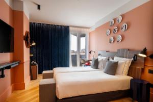 a hotel room with two beds and a television at Urban Hive Milano in Milan