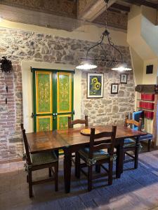 a dining room table with chairs and a stone wall at La Casina di Pinutte in Campagnatico