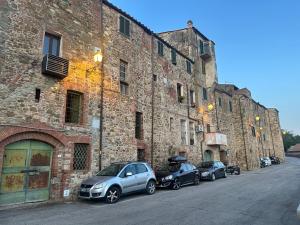 a row of cars parked next to a brick building at La Casina di Pinutte in Campagnatico +10 photos