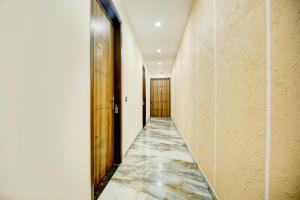a corridor with a marble floor and a hallway with doors at Hotel O Platinum in Zirakpur