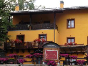 ein gelbes Gebäude mit Blumen auf den Balkonen in der Unterkunft La Maison Du Bon Megnadzo in Doues