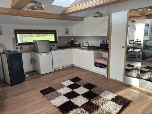a kitchen with white cabinets and a black and white rug at Aqua Garden Junior Miercurea Ciuc in Miercurea-Ciuc